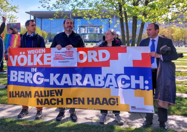 Demonstration outside chancellor’s office, with a sign on a Karabakh flag saying “For genocide in Nagorno Karabakh, send Aliyev to the Hague.” (Gabi Damm photo)